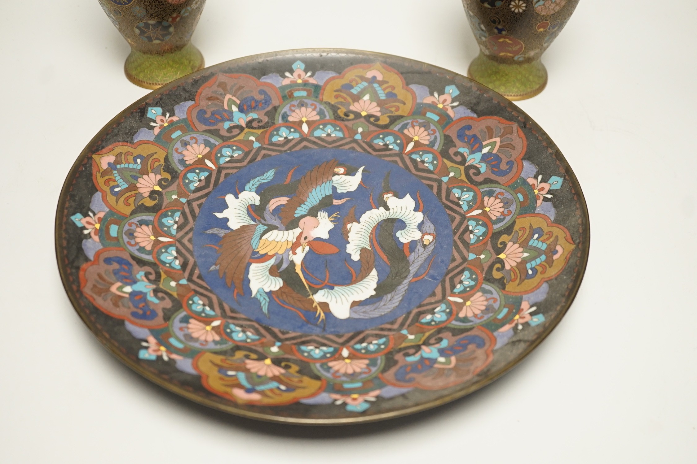 A Japanese cloisonné enamel dish, 30.5cm diameter and a pair of Japanese cloisonné enamel vases. (3)